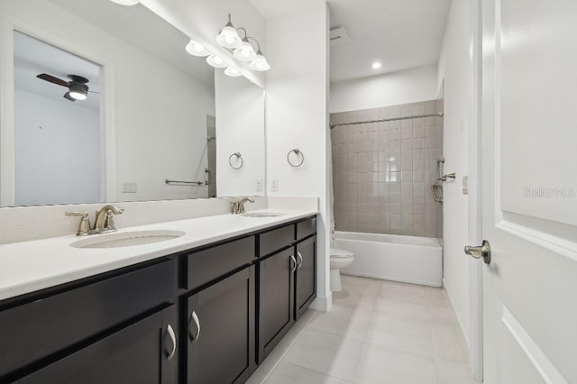 full bathroom featuring ceiling fan, tiled shower / bath, vanity, tile patterned floors, and toilet