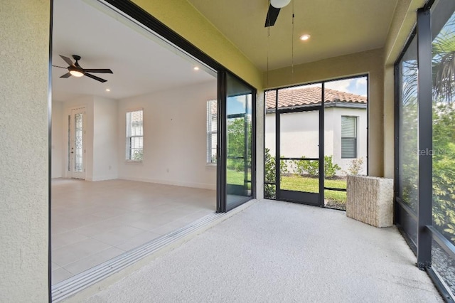 unfurnished sunroom with ceiling fan and a healthy amount of sunlight