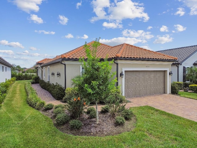 mediterranean / spanish home featuring a garage and a front lawn