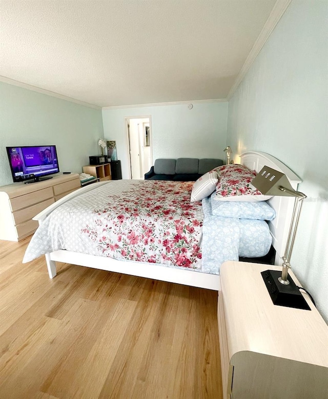 bedroom with hardwood / wood-style flooring, crown molding, and a textured ceiling