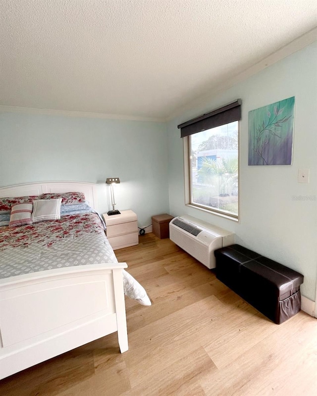 bedroom featuring light hardwood / wood-style flooring and a textured ceiling