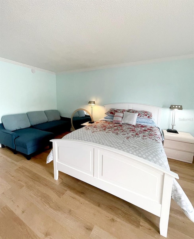 bedroom with a textured ceiling and light wood-type flooring