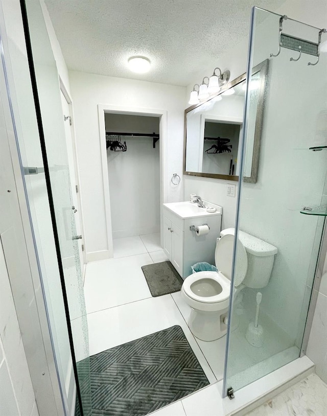 bathroom with toilet, a shower, a textured ceiling, vanity, and tile patterned flooring