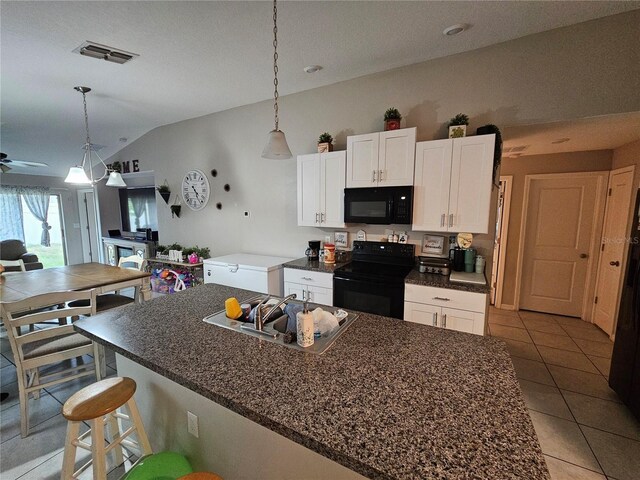 kitchen featuring lofted ceiling, black appliances, white cabinetry, and sink