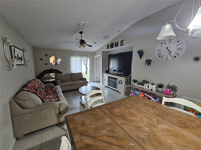 living room featuring a textured ceiling, lofted ceiling, ceiling fan, and tile patterned flooring