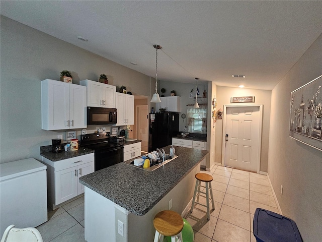 kitchen featuring white cabinetry, black appliances, a center island, a breakfast bar, and lofted ceiling