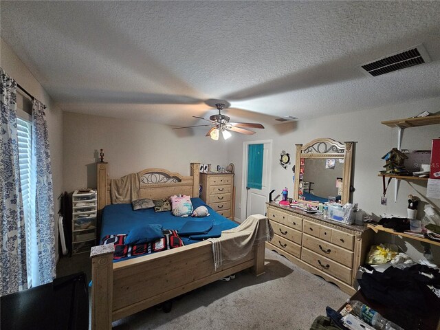 carpeted bedroom featuring a textured ceiling and ceiling fan