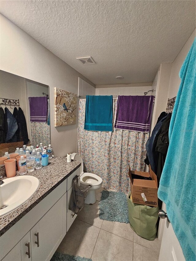 bathroom featuring a textured ceiling, vanity, tile patterned flooring, toilet, and a shower with curtain