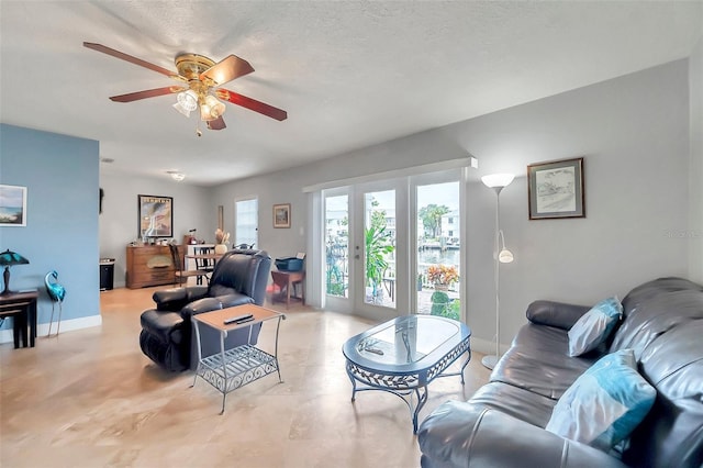 living room with ceiling fan and a textured ceiling