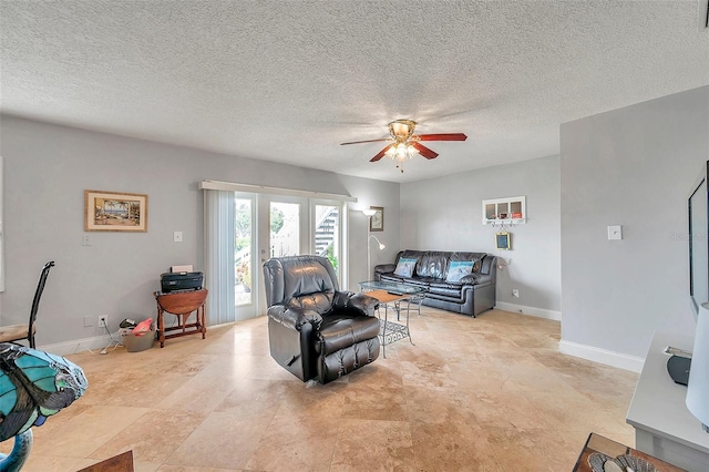 living room featuring ceiling fan and a textured ceiling