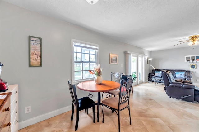 dining area with a textured ceiling and ceiling fan