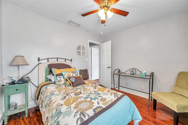 bedroom featuring a textured ceiling, dark wood-type flooring, and ceiling fan