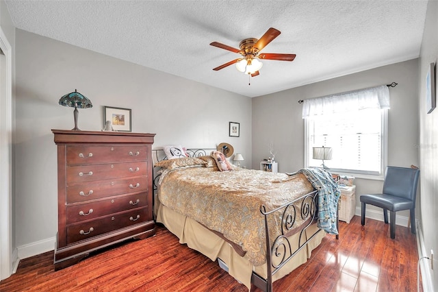 bedroom featuring ceiling fan, dark wood-type flooring, and a textured ceiling