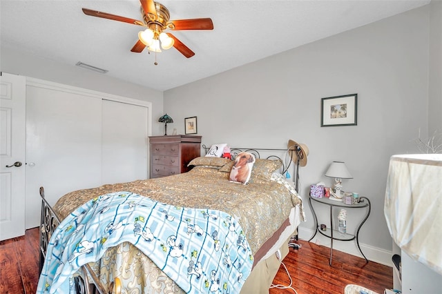 bedroom with a closet, ceiling fan, dark wood-type flooring, and a textured ceiling