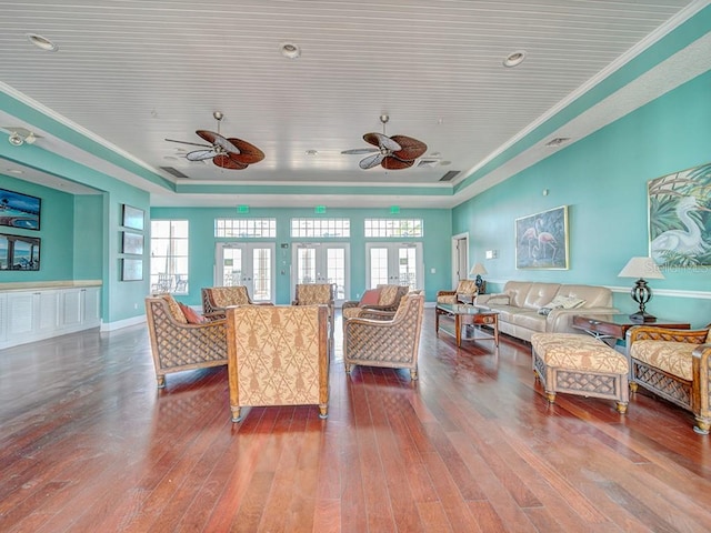 living room featuring crown molding, hardwood / wood-style floors, ceiling fan, and a raised ceiling