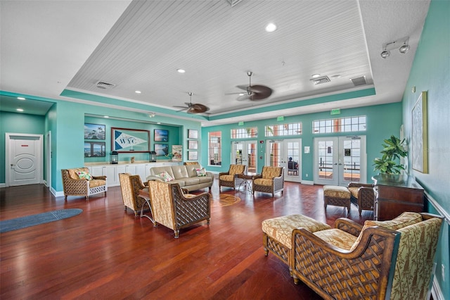 living room with french doors, hardwood / wood-style flooring, a raised ceiling, and ceiling fan