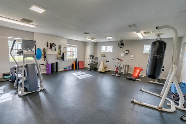 workout area with a textured ceiling and a healthy amount of sunlight