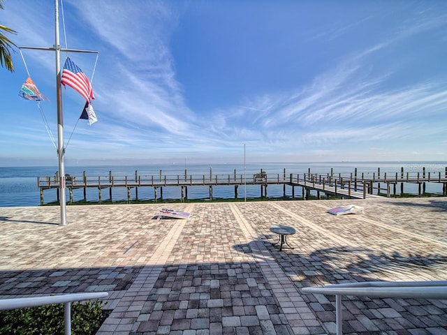 view of patio with a dock and a water view