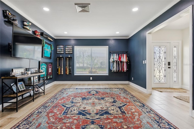 interior space with ornamental molding and light hardwood / wood-style flooring