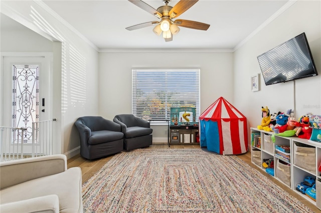 interior space with crown molding, a wealth of natural light, ceiling fan, and light wood-type flooring