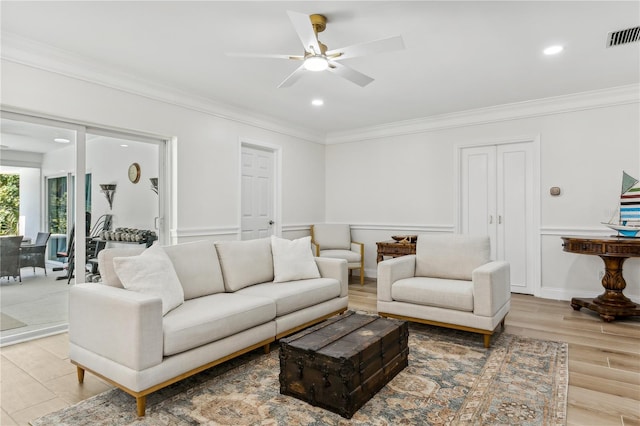 living room with ceiling fan, ornamental molding, and light hardwood / wood-style flooring