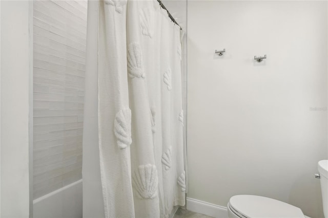 bathroom featuring shower / bathtub combination with curtain and toilet