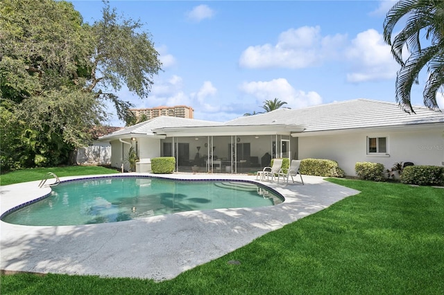 back of property featuring a yard, a sunroom, and a patio