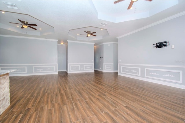 empty room featuring crown molding, ceiling fan, a tray ceiling, and dark hardwood / wood-style flooring