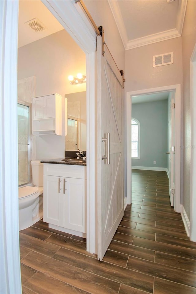 hallway with sink, ornamental molding, and a barn door