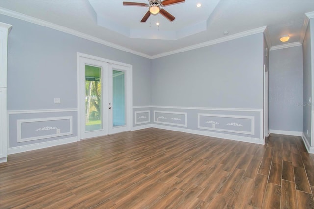 empty room with ceiling fan, ornamental molding, dark hardwood / wood-style flooring, and a tray ceiling