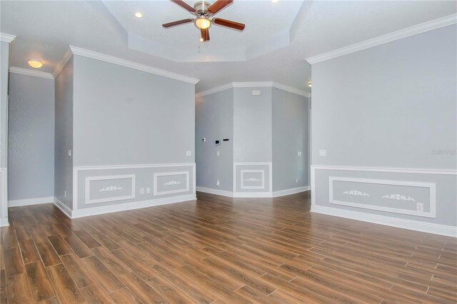 unfurnished living room featuring ceiling fan, crown molding, a tray ceiling, and wood finished floors