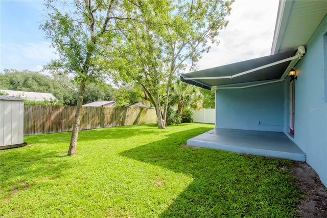 view of yard with a fenced backyard, a storage unit, and an outdoor structure