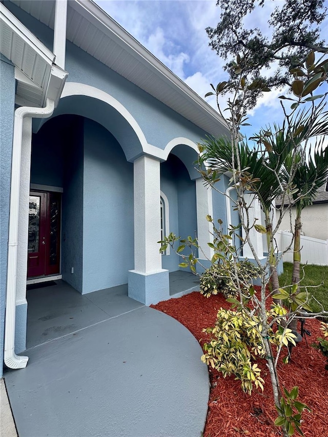 doorway to property featuring stucco siding