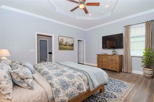 bedroom featuring a raised ceiling, crown molding, baseboards, and wood finished floors