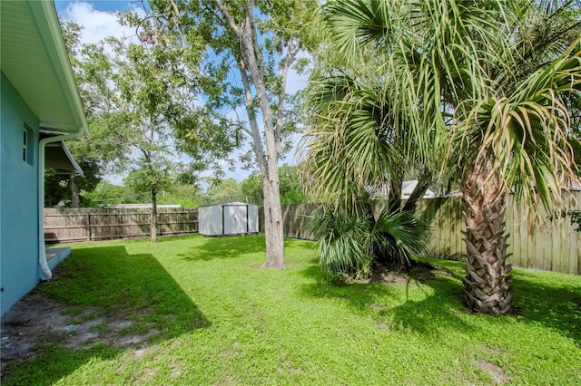 view of yard with an outbuilding, a shed, and a fenced backyard