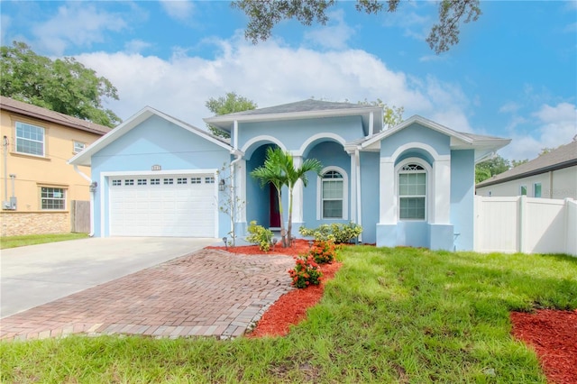 view of front of house with driveway, an attached garage, fence, and stucco siding