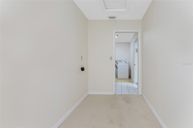 hallway featuring light carpet and washer / dryer