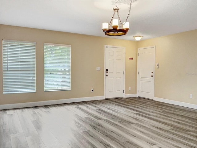 foyer entrance featuring a chandelier and light hardwood / wood-style floors