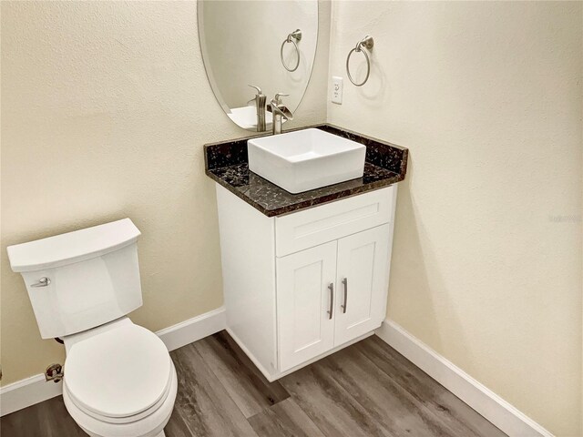 bathroom featuring vanity, toilet, and hardwood / wood-style floors