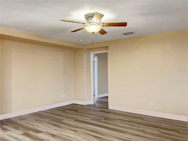 spare room featuring ceiling fan, wood-type flooring, and a textured ceiling