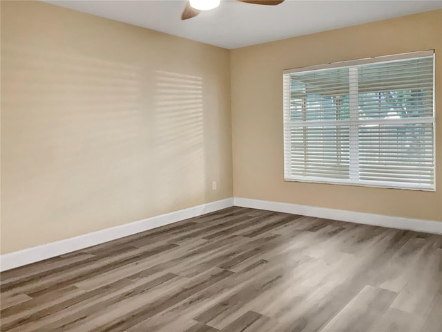 empty room with ceiling fan and hardwood / wood-style flooring