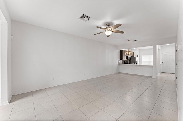 unfurnished living room featuring ceiling fan with notable chandelier and light tile patterned floors