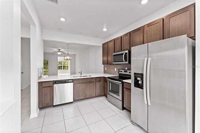 kitchen with ceiling fan, sink, kitchen peninsula, decorative light fixtures, and stainless steel appliances