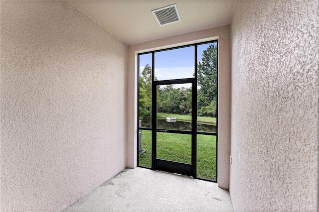 view of exterior entry with a balcony