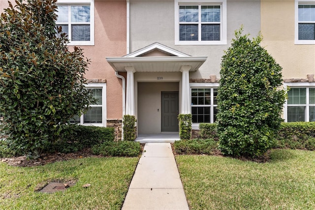 property entrance featuring a lawn