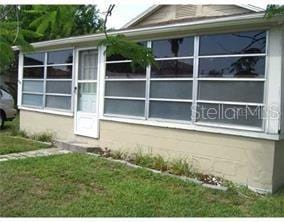 view of property exterior with a sunroom