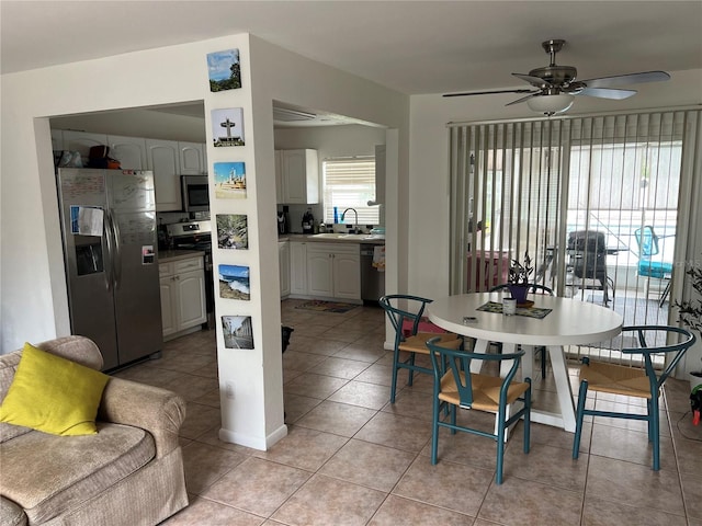 tiled dining area with ceiling fan and sink