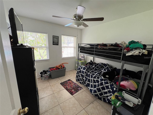 tiled bedroom featuring ceiling fan