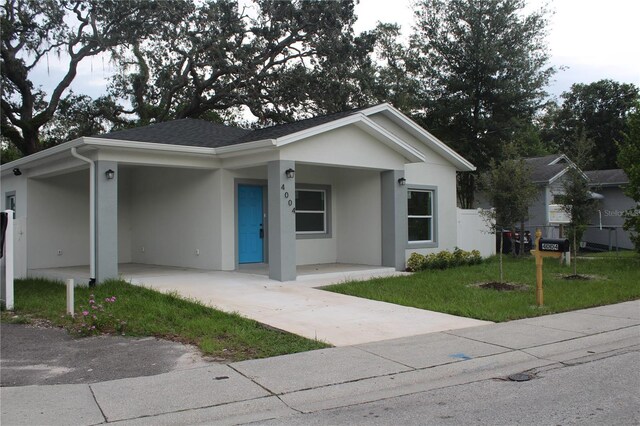 view of front facade featuring a carport and a front yard