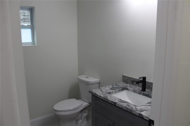 bathroom featuring vanity, tile patterned flooring, and toilet